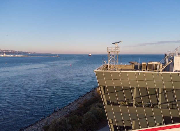 Control tower of ships with big cargo ship entering the port at the evening