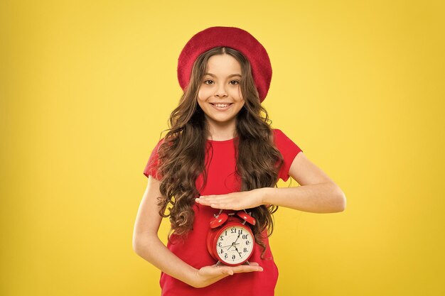 개인 시간 제어 모든 것이 제어됨 자신의 삶의 리듬 정의 일정 및 시간 알람 시계 설정 어린 소녀는 빨간 시계를 들고 항상 정시에 너무 늦지 않았습니다.