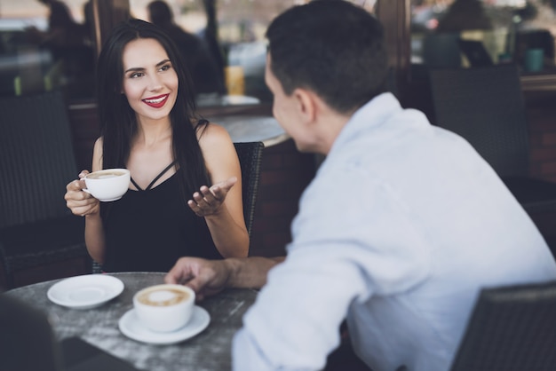 Conversation of girl with man in cafe for coffee mug.