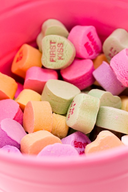 Photo conversation heart candies in pink bucket.