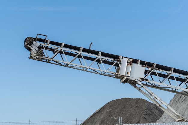 Conveyor crusher on contruction site with Piles of Sand and earth