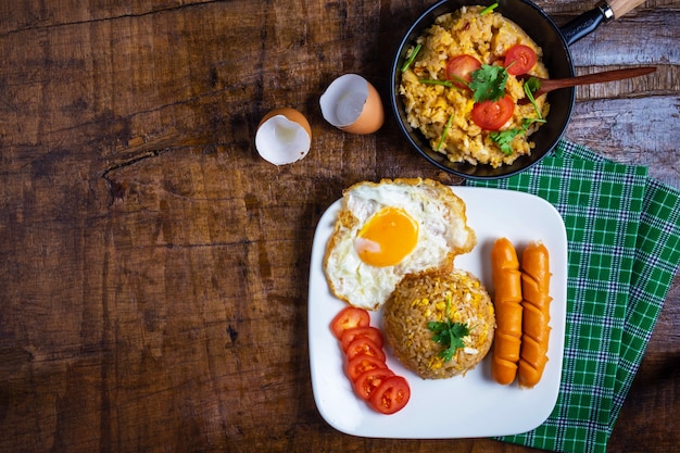 Cook American fried rice in a pan, served with fried eggs and sausages.