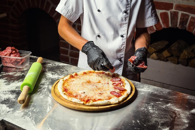 Cook Chef-kok die heerlijke pizza maakt bij de restaurantclose-up