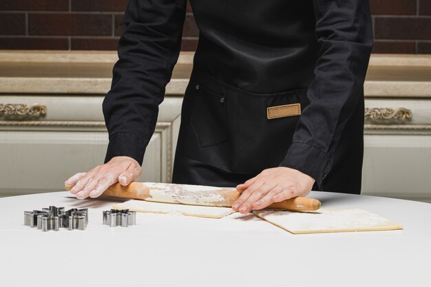 Cook the chef rolls the dough for the cookies.