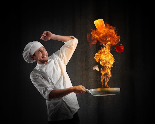 Photo cook chef with a big explosion in kitchen