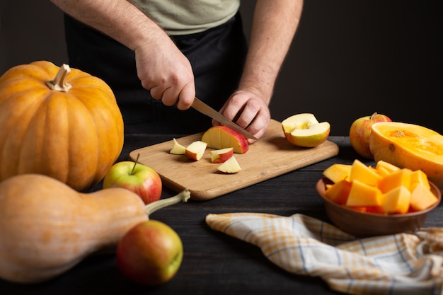 Foto il cuoco taglia la mela a pezzi per cuocerla.