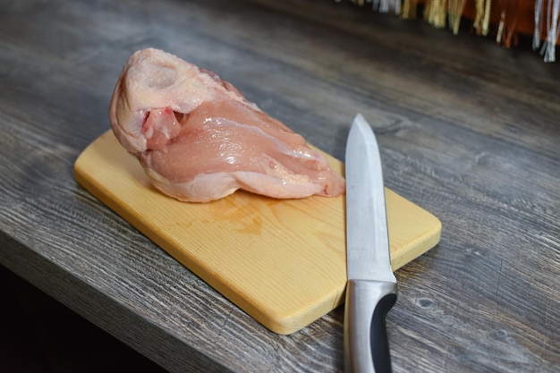 The cook cuts the meat in the kitchen. cooking meat dishes. woman cuts a piece of chicken meat