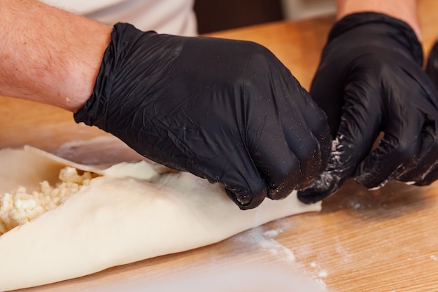 Cook hands preparing khachapuri in a cafe v