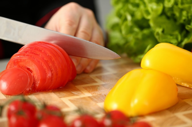 Cook holds knife in hand and cuts