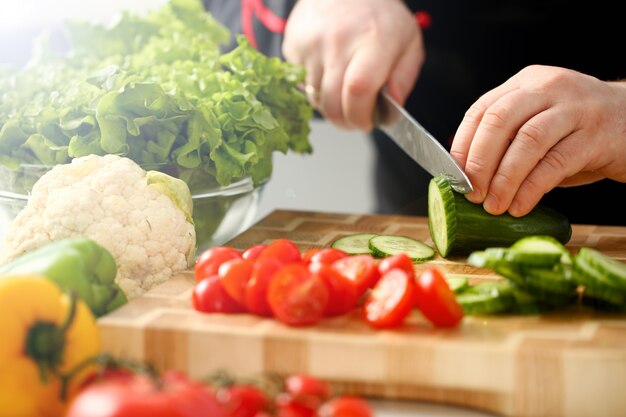 Cook holds knife in hand and cuts on