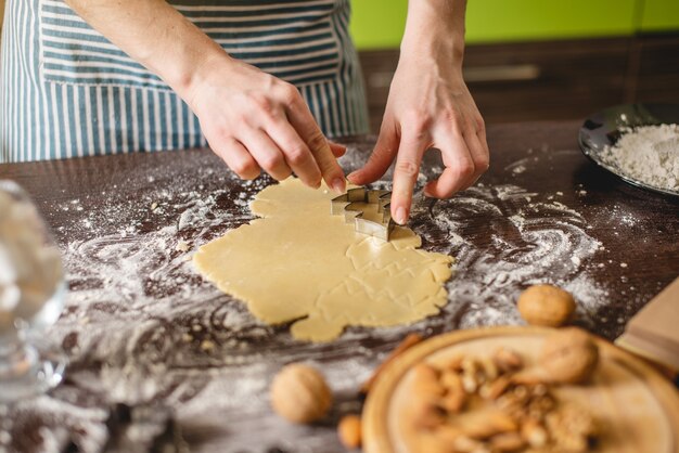 Cook huisvrouw kerstkoekjes thuis maken op een kleurrijke keuken