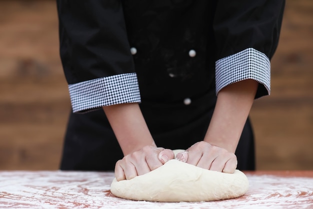 The cook makes flour out of flour for baking on the table