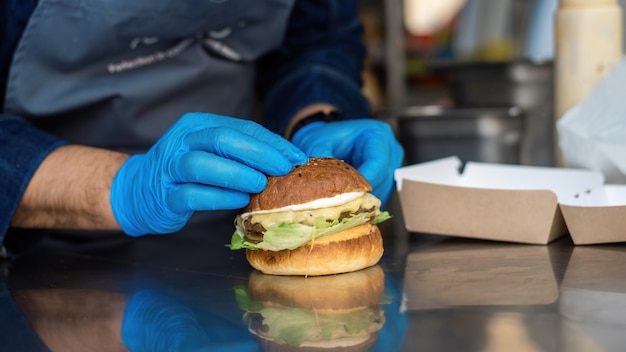 Foto cuoco che prepara hamburger in un camion di cibo