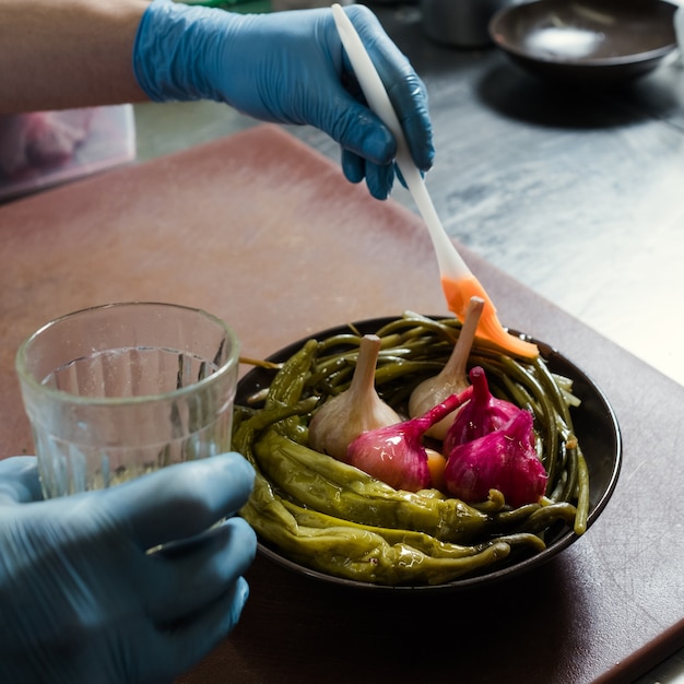 Photo cook oiling pickled vegetables.