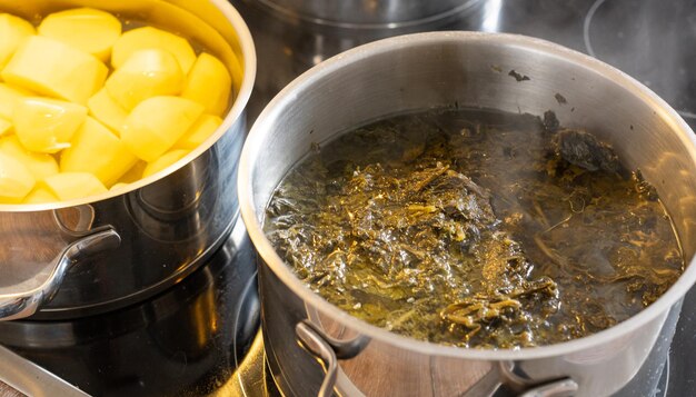 Photo cook potatoes and kale on a stovetop