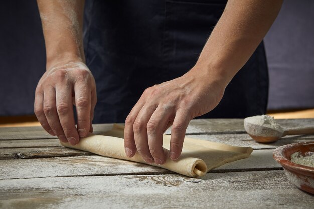 Cook pours flour on bread