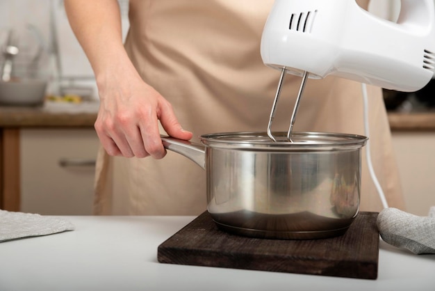 Cook prepares a dough Mixer mixes the ingredients in saucepan