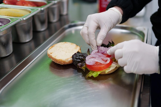 Photo cook prepares vegan burger in her restaurant