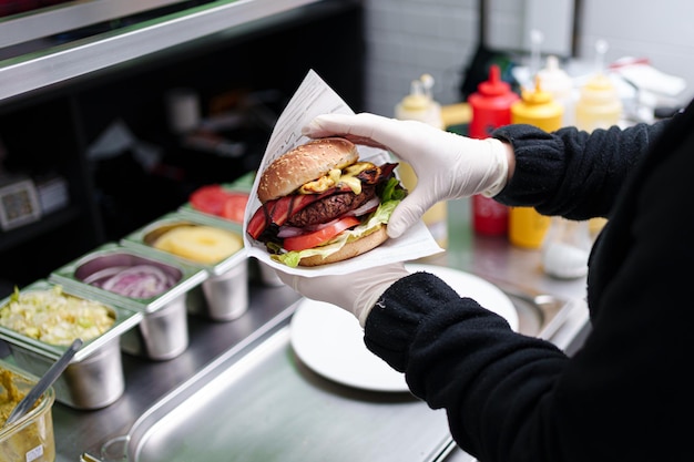 Photo cook prepares vegan burger in her restaurant