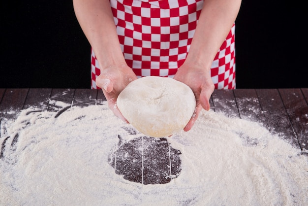 Cook preparing dough for baking in the kitchen