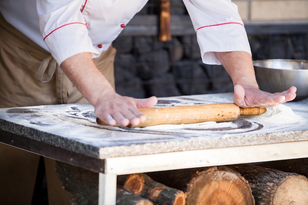 Cook preparing pizza in a restaurant.