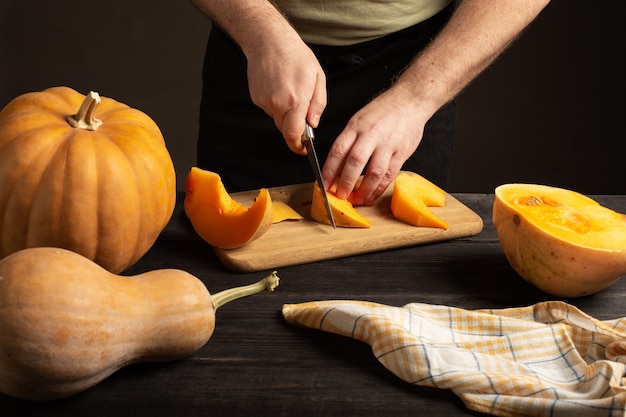 The cook slices the pumpkin for baking.