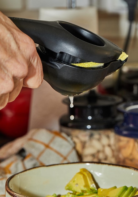 Cook squeezes lemon juice into salad using a special device for preparing salad.