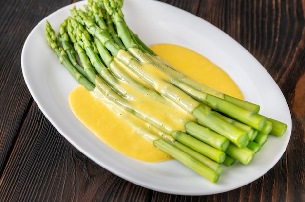 Cooked asparagus with Hollandaise sauce on the serving plate