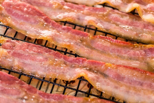 Cooked bacon strips on a baking sheet.