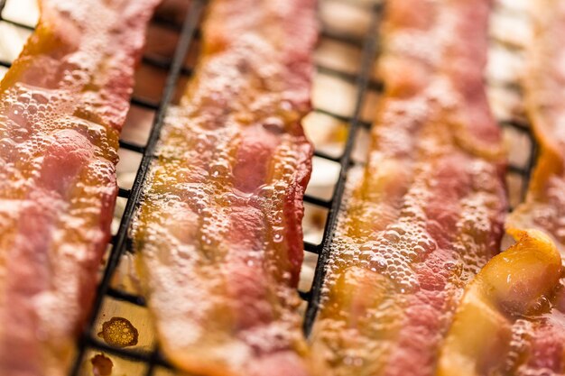 Cooked bacon strips on a baking sheet.