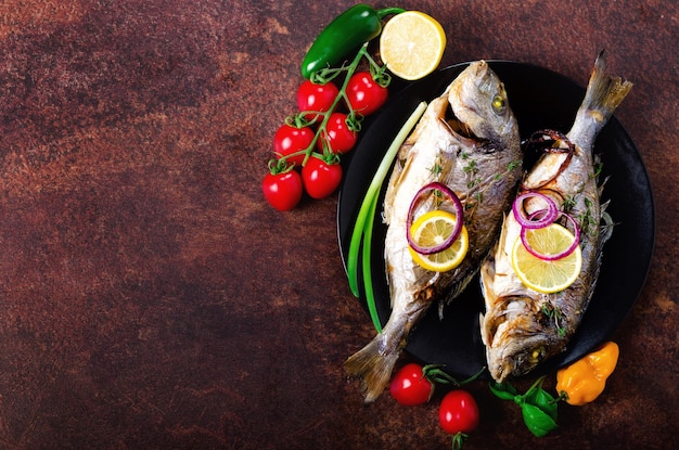 cooked baked grilled fish dorado sea bream with lemon herbs vegetables and spices on rustic background top view copy space