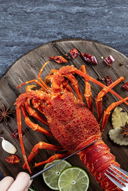 Cooked boiled lobster delicious dinner seafood meal set with knife and fork on black stone slate background restaurant menu design top view overhead
