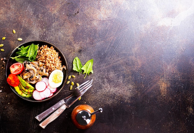 Cooked Buckwheat with avocado and mushrooms served in a bawl for breakfast Gluten free meal