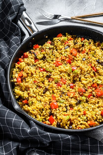 Cooked bulgur with vegetables in a pan