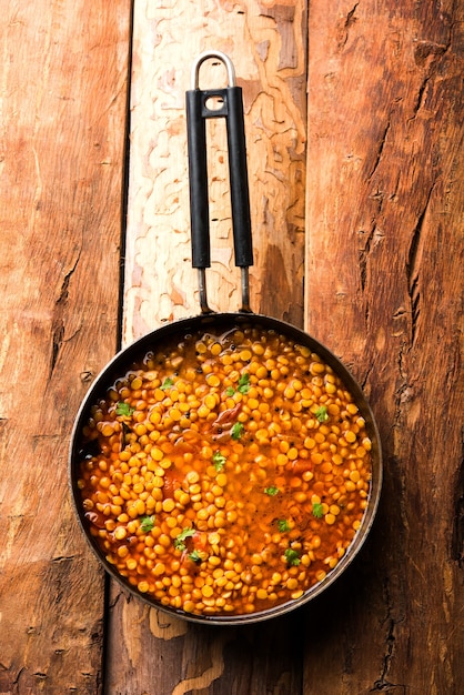 Foto chana dal fry cotto o split bengal gram tadka servito in una ciotola o padella, fuoco selettivo