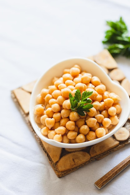 Cooked chickpeas in white bowl Ingredient for Tasty vegetarian food Boiled chickpeas selective focus