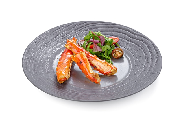 Cooked crab claws with salad isolated on white