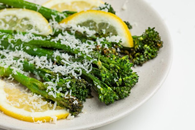 Photo cooked fresh broccolini with grated cheese on the plate