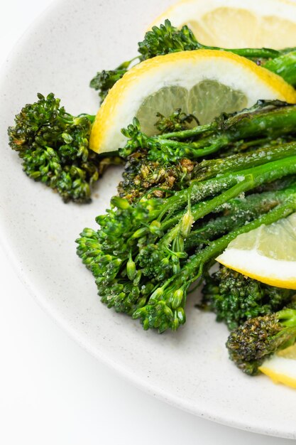 Photo cooked fresh broccolini with lemon on the plate