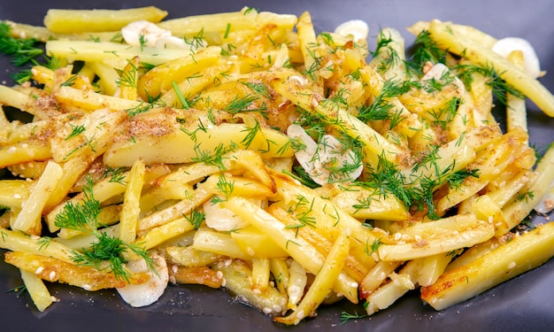 Photo cooked fried potatoes with herbs and vegetables on a plate