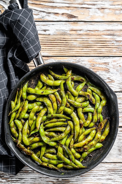 Cooked green edamame soybeans in a pan, japanese food.  White background. Top view