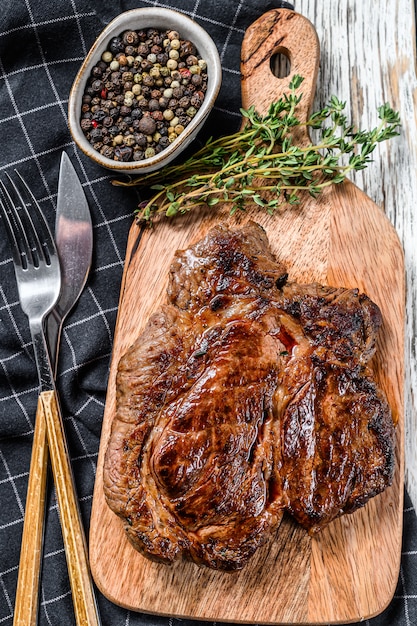 Cooked grilled Chuck eye roll steak on a chopping Board