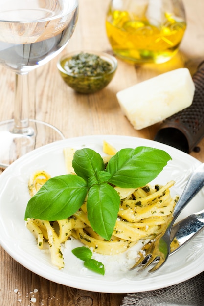 Cooked homemade pasta with pesto and basil