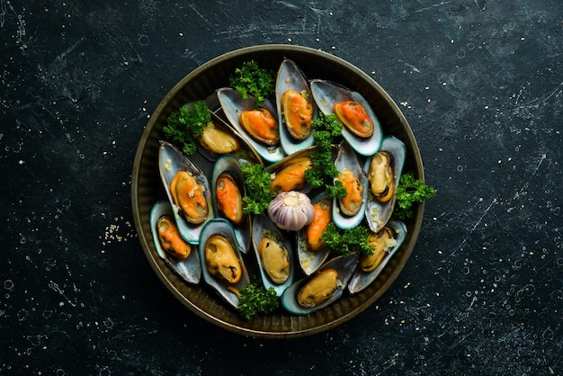 Cooked large green mussels with garlic parsley and lemon on a metal tray Seafood Free space for text