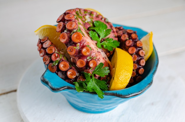 Cooked marinated octopus in a blue bowl . Close up, top view. Asian cuisine