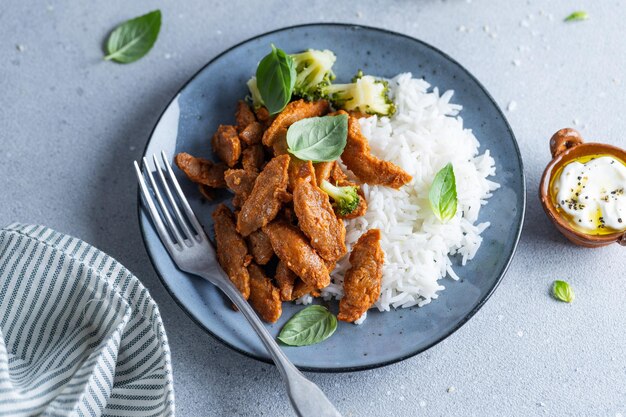 Photo cooked meat with rice on plate on grey background closeup