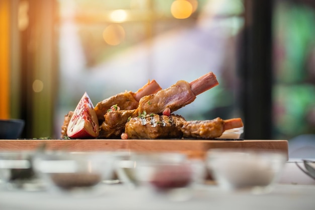 Cooked meat on wooden board piece of pomegranate veal ribs served with fruit breakfast in bistro