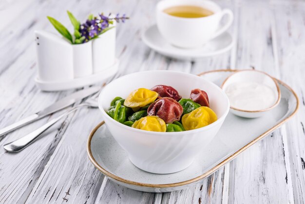 Cooked multicolored tortellini dumplings closeup in a bowl