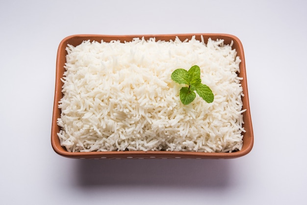 Приготовленный простой белый рис басмати в терракотовой миске