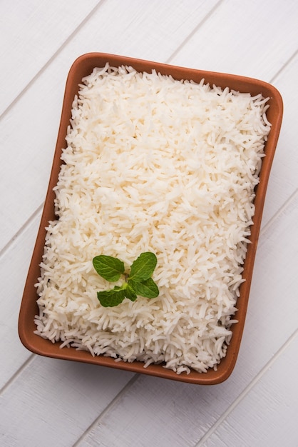 Приготовленный простой белый рис басмати в терракотовой миске